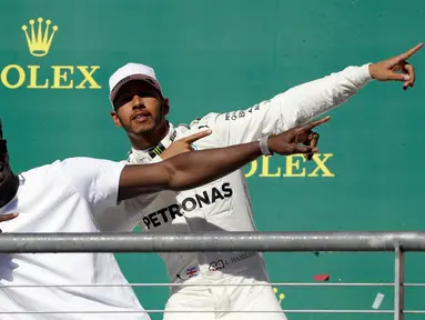 Pembalap asal Inggris dari tim Marcedes, Lewis Hamilton berpose dengan mantan atlet lari cepat asal Jamaika, Usain Bolt di atas podium setelah berhasil memenangi balapan GP Amerika Serikat di Circuit of Americas, Minggu (22/10). (AP Photo/Tony Gutierrez)