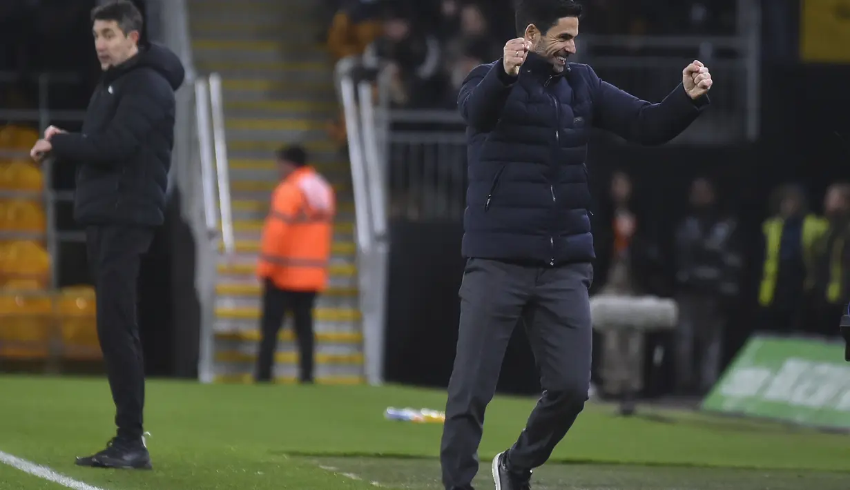 Pelatih Arsenal, Mikel Arteta (kanan) merayakan kemenangan timnya atas Wolverhampton Wanderers pada pertandingan lanjutan Liga Inggris di stadion Molineux di Wolverhampton, Inggris, Jumat (11/2/2022). Arsenal menang tipis atas Wolverhampton Wande 1-0. (AP Photo/Rui Vieira)