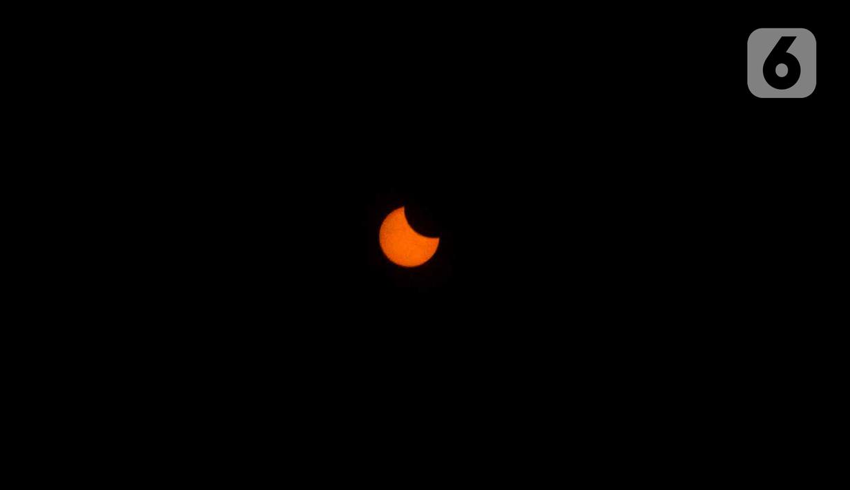 Fase gerhana matahari cincin terlihat dari Planetarium Taman Ismail Marzuki, Jakarta, Kamis (26/12/2019). Planetarium menyediakan sekitar 10 teleskop dan kacamata khusus agar pengunjung bisa menyaksikan gerhana matahari cincin dengan aman. (Liputan6.com/Faizal Fanani)