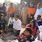 Presiden Joko Widodo atau Jokowi bersama Gubernur NTB Tuan Guru Bajang (TGB) Zainul Majdi berbincang anak-anak saat mengunjungi korban gempa di Desa Madayin, Sambelia, Lombok Timur, NTB, Senin (30/7). (Agus Suparto/Indonesian Presidential Palace/AFP)