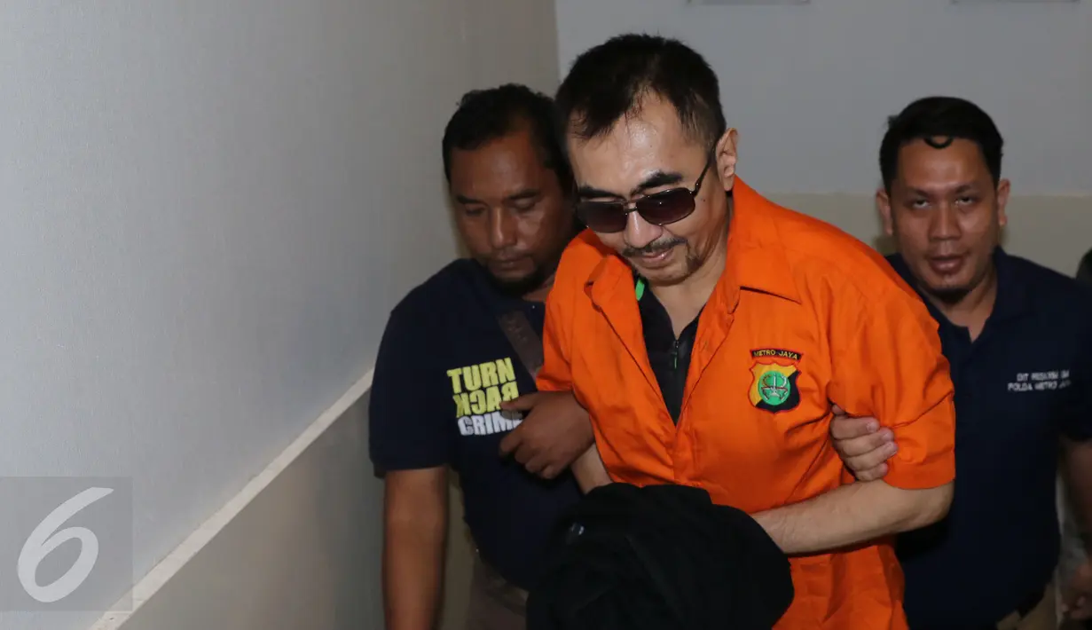 Mantan Ketua Parfi, Gatot Brajamusti dikawal petugas menuju ruang penyidik Polda Metro Jaya, Jumat (21/10). Gatot diterbangkan dari Polda NTB ke Jakarta untuk menjalani pemeriksaan terkait rentetan kasus yang menjeratnya. (Liputan6.com/Herman Zakharia)