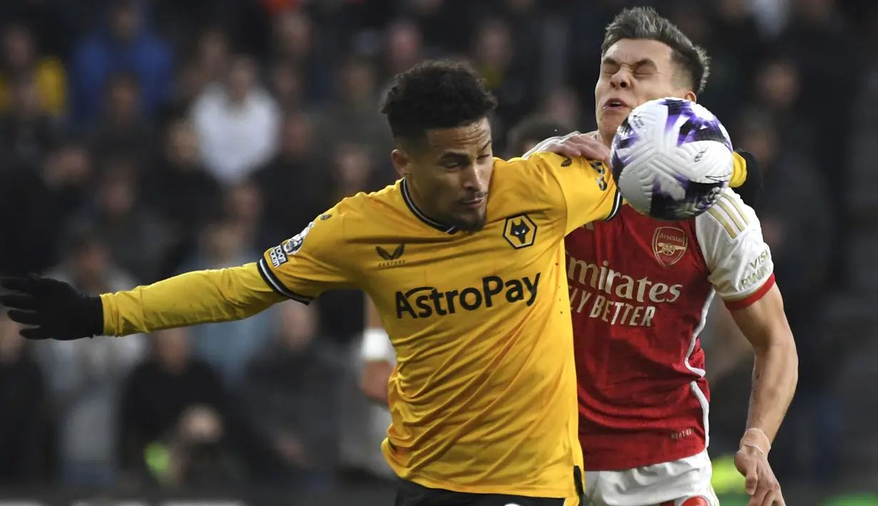 Gelandang Wolverhampton Wanderers, Joao Gomes (kiri) berebut bola dengan gelandang Arsenal, Leandro Trossard pada laga pekan ke-33 Premier League 2023/2024 di Molineux Stadium, Wolverhampton, Sabtu (20/4/2024). (AP Photo/Rui Vieira)