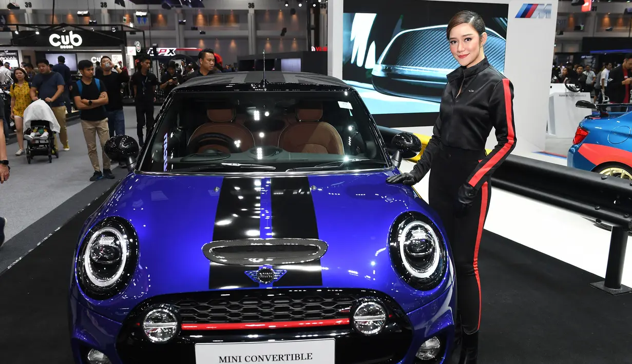 Model berpose di samping convertible Mini S 2018 selama Thailand International Motor Expo di Bangkok (29/11). Pameran ini menampilkan peserta dari 36 pembuat dari 9 negara plus 23 merek sepeda motor dari 7 negara. (AFP Photo/Lillian Suwanrumpha)