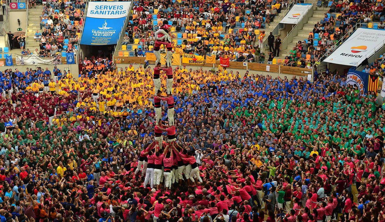 Sebuah tradisi menarik ada di Spanyol yaitu Kompetisi Taragon Castells, Spanyol, Sabtu (1/10). Kompetisi Taragon Castells adalah kompetisi membuat menara manusia. (AFP PHOTO / Lluis Gene)