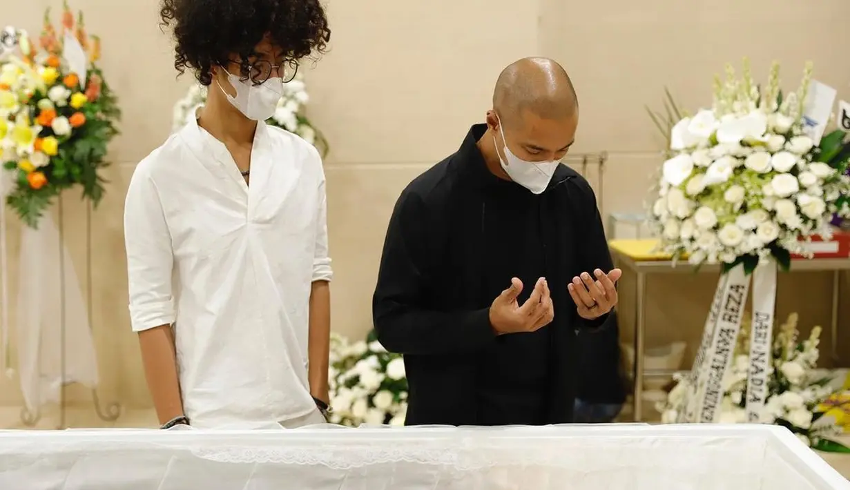 Dee Lestari mengunggah 10 foto di akun Instagram terverifikasinya, Selasa (13/9/2022) yang menampilkan suasana di ruang duka, diduga beberapa saat sebelum jenazah Reza Gunawan dikremasi. Salah satunya tampak Marcell Siahaan berdoa menurut keyakinannya. Kehangatan cinta, kesejukan toleransi, dan eratnya pertalian keluarga tergambar jelas dalam foto ini. (Foto: Dok. Hanafi dari Instagram @deelestari)