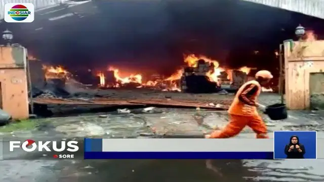 Dengan alat seadanya, sejumlah warga berupaya memadamkan api yang membakar sebuah percetakan di kawasan Salemba.
