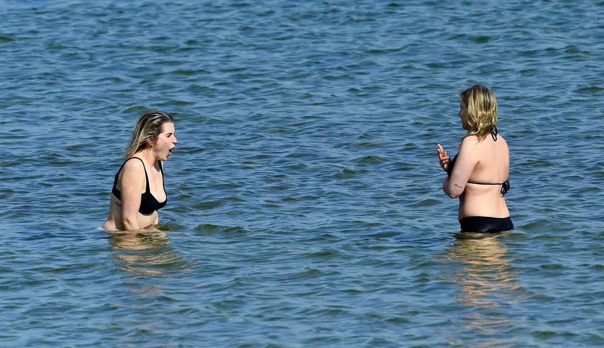 Warga berenang di sebuah pantai di Melbourne, Australia, Kamis (19/8/2021). Melbourne melewati 200 hari dalam lockdown keras sejak dimulainya pandemi COVID-19. (William WEST/AFP)
