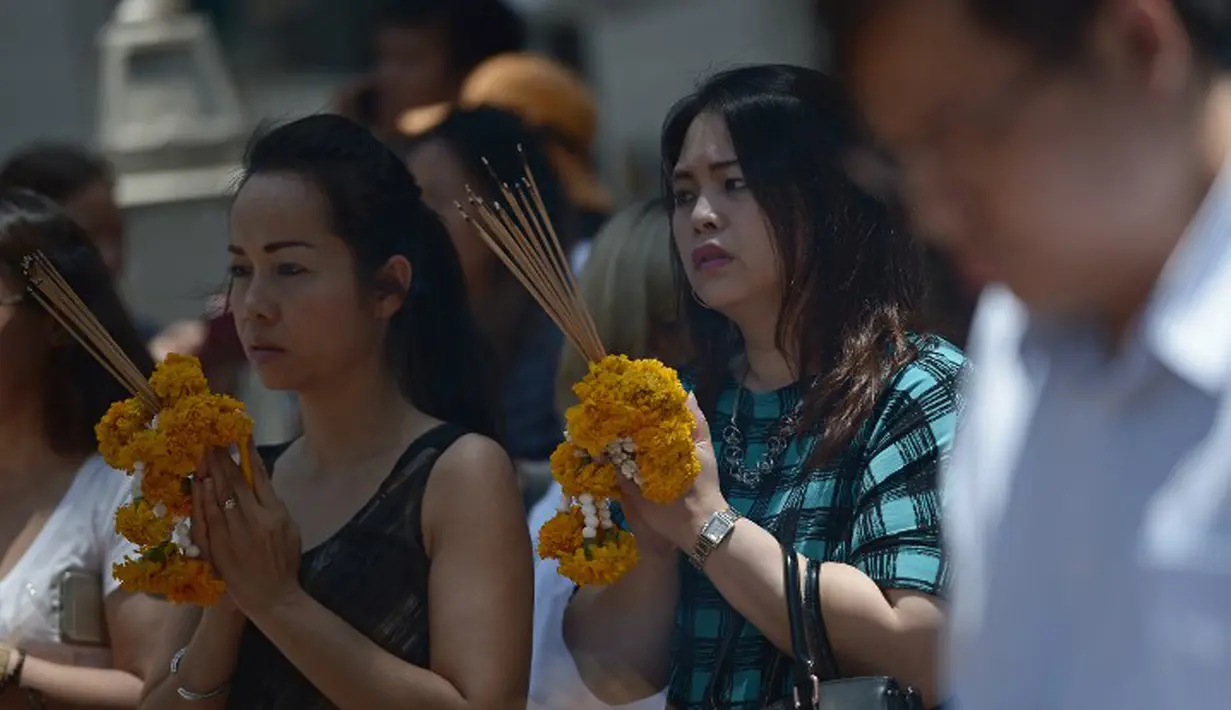 Sejumlah warga melakukan doa bersama di sekitar lokasi kejadian ledakan bom di Thailand), Bangkok, Rabu (19/8/2015). Peristiwa tersebut dikabarkan telah menewaskan sekitar 20 orang. (AFP Photo/Jerome Taylor)