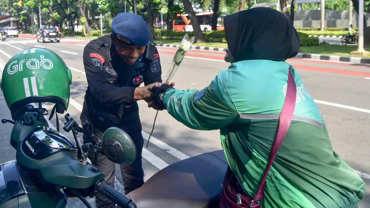 FOTO: Aksi Damai Ojol Tebar Mawar untuk Perdamaian