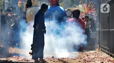 Warga memegang petasan besar yang dibakar saat kegiatan pawai jelang Ramadan di kawasan Pondok Cabe Ilir, Tangerang Selatan, Banten, Minggu (27/3/2022). Kegiatan yang diselenggarakan Sanggar Seni Rumah Baba ini diikuti puluhan warga. (merdeka.com/Arie Basuki)