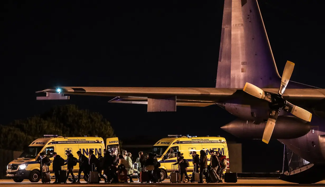Penumpang yang diterbangkan dari Wuhan tiba di pangkalan militer Figo Maduro, Lisbon, Portugal, Minggu (2/2/2020). Portugal memulangkan warganya dari Wuhan menyusul wabah virus corona di kota tersebut. (Photo by MÁRIO CRUZ/POOL/AFP)