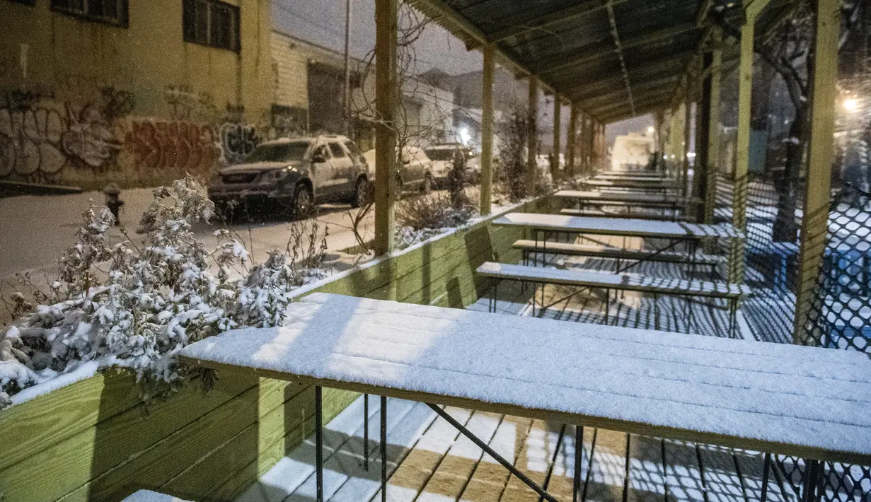 Area makan luar ruangan yang tertutup salju akibat badai salju di bagian Ridgewood di distrik Queens, New York, Sabtu (29/1/2022). Orang-orang dari New York City hingga Maine terbangun karena salju tebal dan angin kencang saat badai Nor'easter yang kuat melanda. (AP Photo/Brittainy Newman)