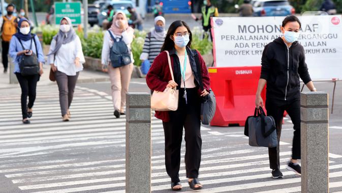 Pejalan kaki melintasi lajur penyebrangan di Jalan Jenderal Sudirman, Jakarta, Rabu (23//9/2020). Menteri Keuangan Sri Mulyani Indrawati memastikan ekonomi nasional resesi pada kuartal III-2020. Kondisi ini akan berdampak pada pelemahan daya beli hingga PHK. (Liputan6.com/Helmi Fithriansyah)