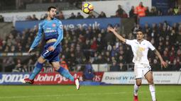 Aksi pemain Arsenal, Henrikh Mkhitaryan menyundul bola saat melawan Swansea City pada lanjutan Premier League di Liberty Stadium, Swansea, Wales, (30/1/2018). Arsenal kalah 1-3. (Nick Potts/PA via AP)