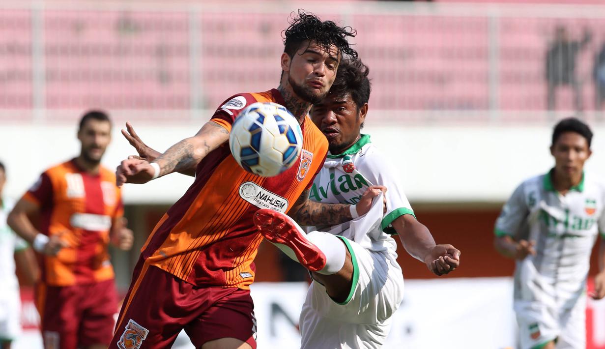 Pemain Surabaya United, Ilham Udin Armaiyn, berebut bola dengan pemain Pusamania Borneo FC, Diego Michiels, pada babak 8 besar Piala Jenderal Sudirman di Stadion Maguwoharjo, Sleman, Minggu (13/12/2015). (Bola.com/Nick Hanoatubun)