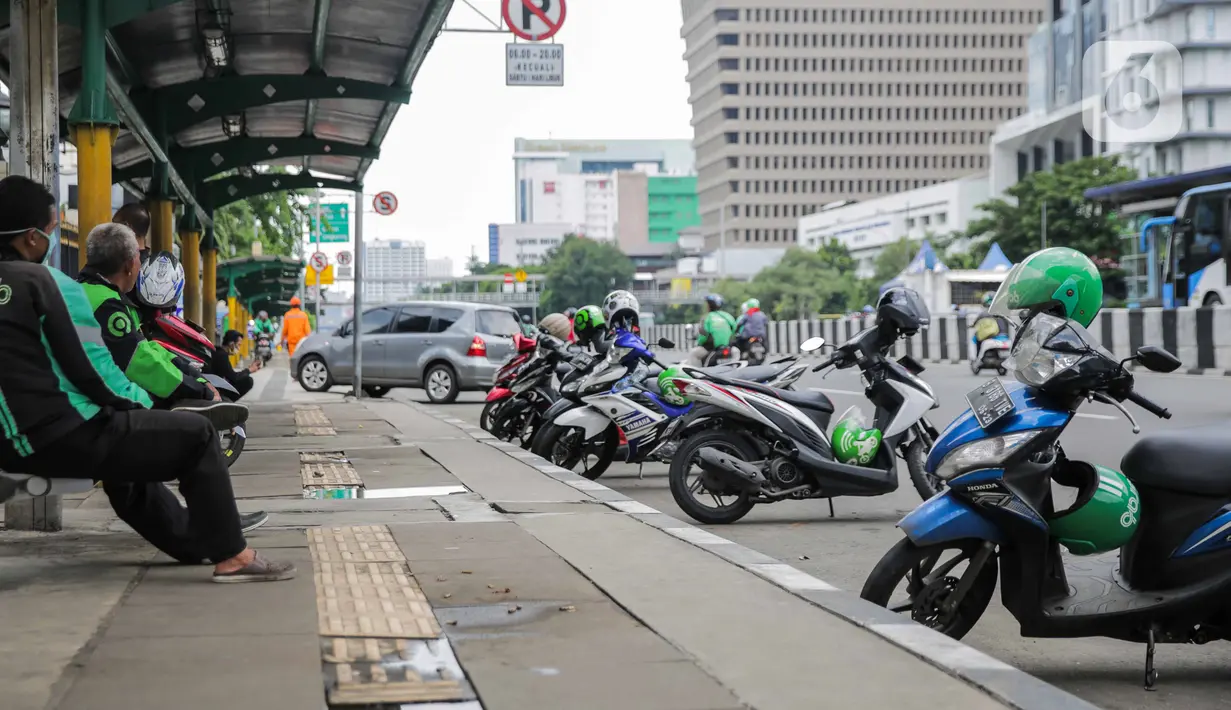 Sejumlah pengemudi ojek online beristirahat di sebuah halte di kawasan Harmoni, Jakarta, Selasa (7/4/2020). Selama pemberlakuan Pembatasan Sosial Berskala Besar (PSBB), layanan ojek online (ojol) akan dilarang mengangkut penumpang dan hanya dibolehkan untuk antar barang. (Liputan6.com/Faizal Fanani)