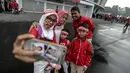 Satu keluarga suporter Timnas Indonesia berpose di depan Stadion Gelora Bung Karno (GBK), Senayan, Jakarta, Minggu (14/1). Menghadapi Islandia, Timnas Indonesia akan didominasi oleh pemain U-23. (Liputan6/Faizal Fanani)