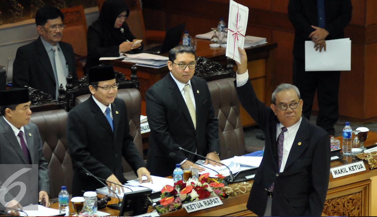 Ketua Komisi II DPR Rambe Kamarulzaman menyerahkan hasil pandangannya terkait pengesahan Revisi UU tentang Pilkada keada Ketua Sidang Taufik Kurniawan disaksikan Ketua DPR Ade Komarudin (kedua kanan), Jakarta, Kamis (2/6/2016). (Liputan6.com/Johan Tallo)