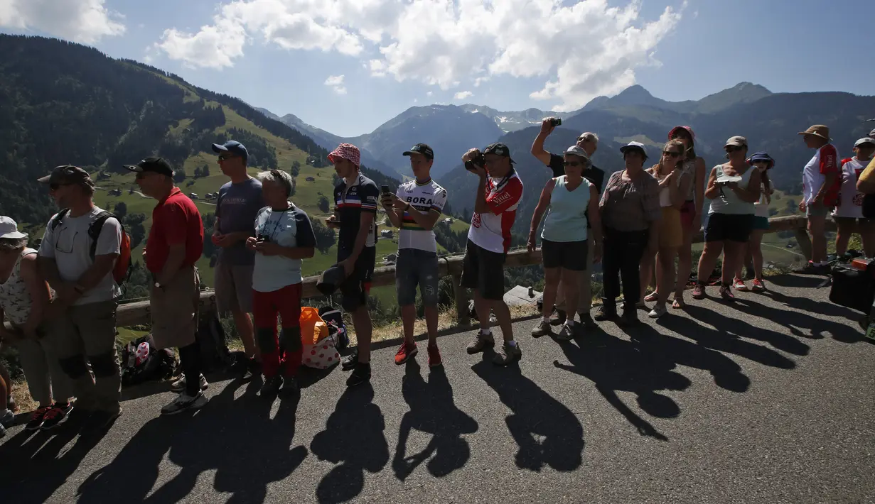 Penonton menanti pebalap yang akan melintas pada etape ke-11 Tour de France dari Albertville dan finish di La Rosiere Espace San BernardoPrancis (18/7/2018). Etape ini menempuh jarak 108.5 kilometers. (AP/Christophe Ena)