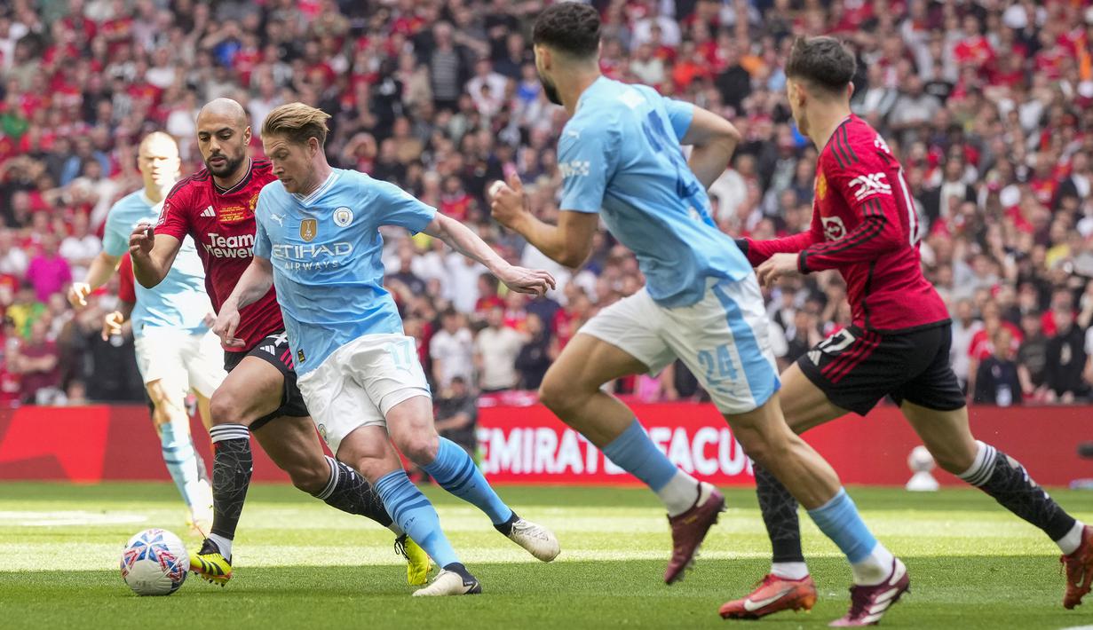 Pemain Manchester United, Sofyan Amrabat (kedua kiri) berusaha merebut bola dari pemain Manchester City, Kevin De Bruyne saat laga final Piala FA 2023/2024 di Stadion Wembley, London, Sabtu (26/05/2024). (AP Photo/Kin Cheung)