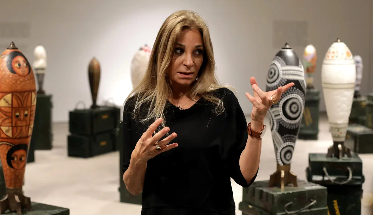 Seniman Lebanon, Katya Traboulsi berbicara tentang karyanya yang dipamerkan di Salih Barakat Gallery, Beirut, Selasa (10/4). Sang seniman menampilkan replika bom warna-warni untuk mengenang kepahitan perang saudara di Lebanon. (ANWAR AMRO/AFP)