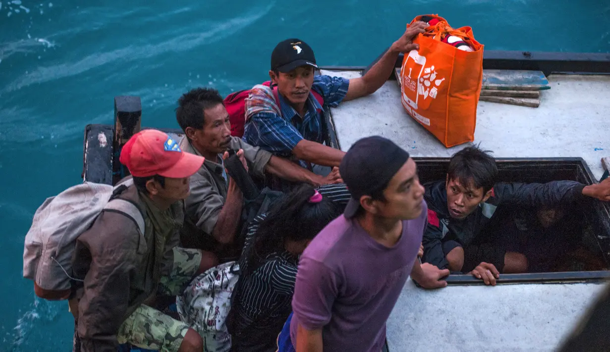 Penduduk Pulau Sebuku menunggu proses evakuasi sebelum menaiki kapal TNI Angkatan Laut dari rumah mereka yang terkena dampak tsunami di perairan Selat Sunda (28/12). (AP Photo/Fauzy Chaniago)