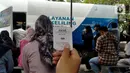 Warga menunjukkan nomor antrean selama proses perpanjang SIM A dan SIM C saat Pelayanan SIM Keliling di Plaza Jambu Dua, Kota Bogor, Sabtu (5/11/2022). Polresta Bogor Kota telah mempersiapkan beberapa titik lokasi pelayanan di wilayah Kota Bogor, warga hanya perlu membawa SIM A/C asli yang hendak diperpanjang masa berlakunya dan menyertakan fotocopy E-KTP. (Liputan6.com/Magang/Aida Nuralifa)