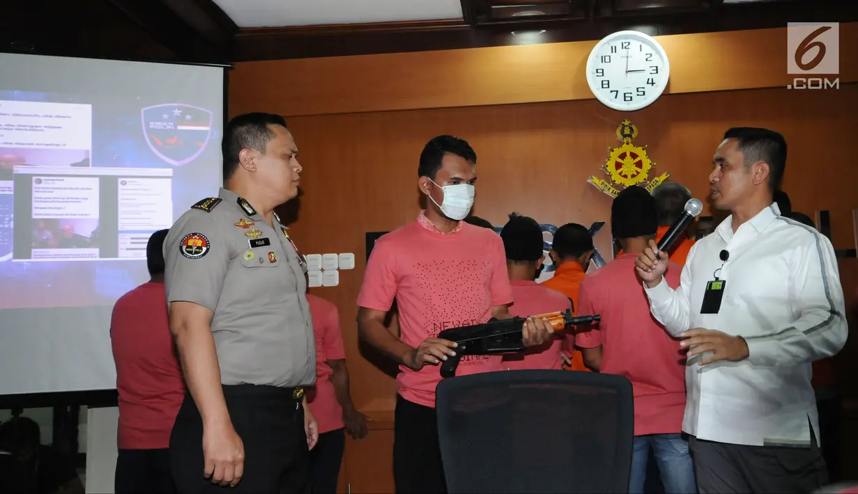 Kasubdit I Dittipid Siber Bareskrim Polri Kombes Pol Irwan Anwar (kanan) menginterograsi salah satu tersangka kejahatan siber saat rilis di Jakarta, Rabu (21/2). Dittipid Siber Bareskrim Polri menahan 10 tersangka. (Liputan6.com/Helmi Fithriansyah)