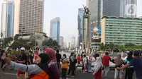 Warga berswafoto di kawasan bundaran HI, Jakarta, Minggu (12/6/2022). Car Free Day di kawasan Sudirman-Thamrin dimanfaatkan warga untuk berolah raga dan ber foto-foto. (Liputan6.com/Herman Zakharia)