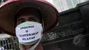Koalisi Rakyat Untuk Keadilan Perikanan (KIARA) melakukan aksi di gedung Kementrian Kelautan dan Perikanan, Jakarta (6/4/2015). Seorang peserta aksi menggunakan masker bertuliskan pesan untuk pemerintah saat ini. (Liputan6.com/Johan Tallo)