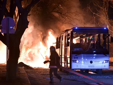 Petugas pemadam bersiap memadamkan api setelah ledakan bom mobil di Ankara, Turki, Rabu (17/2). Bom mobil yang meledak ketika iring-iringan bus militer tengah lewat tersebut menewaskan setidaknya 28 orang.  (REUTERS/Ihlas News Agency TURKEY OUT)