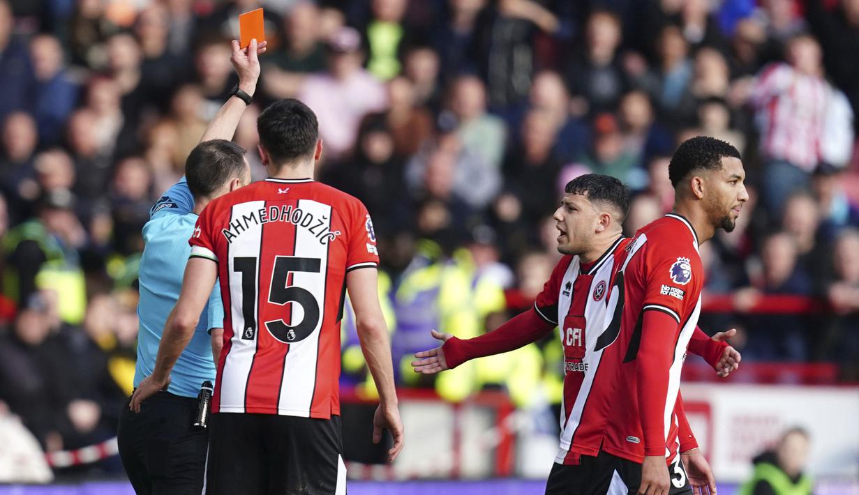 Wasit Stuart Attwell memberikan kartu merah kepada pemain Sheffield United, Mason Holgate setelah meninjau VAR terhadap pelanggaran kerasnya terhadap pemain Brighton, Kaoru Mitoma pada laga lanjutan Liga Inggris 2023/2024 di Bramall Lane stadium, Sheffield, Inggris, Minggu (19/02/2024). (AP Photo/PA/Nick Potts)