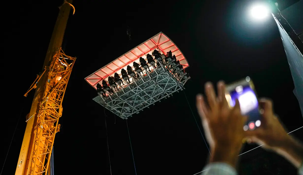 Pengunjung menikmati makan malam di Restoran Altum, Caracas, Venezuela, 22 Desember 2022. Untuk sampai di udara, Restoran Altum ditinggikan dengan derek. (AP Photo/Matias Delacroix)