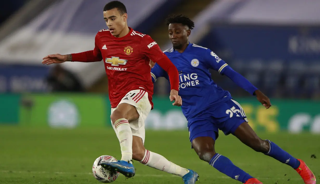 Gelandang MU, Mason Greenwood membawa bola dari kejaran pemain Leicester City, Wilfred Ndidi  pada perempat final Piala FA di Stadion King Power, Inggris (22/3/2021). Dengan hasil ini, Leicester untuk pertama kalinya dalam 39 tahun terakhir lolos ke semi-final FA Cup. (AP Photo/Ian Walton, Pool)