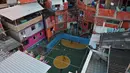 Lapangan kecil di lingkungan Tavares Bastos favela di Rio de Janeiro, Brasil mempunyai daya tarik tersendiri. Bagaimana tidak, lokasi yang sering digunakan untuk syuting film Hollywood tersebut dikelilingi oleh rumah padat penduduk. (AFP/Carl de Souza)