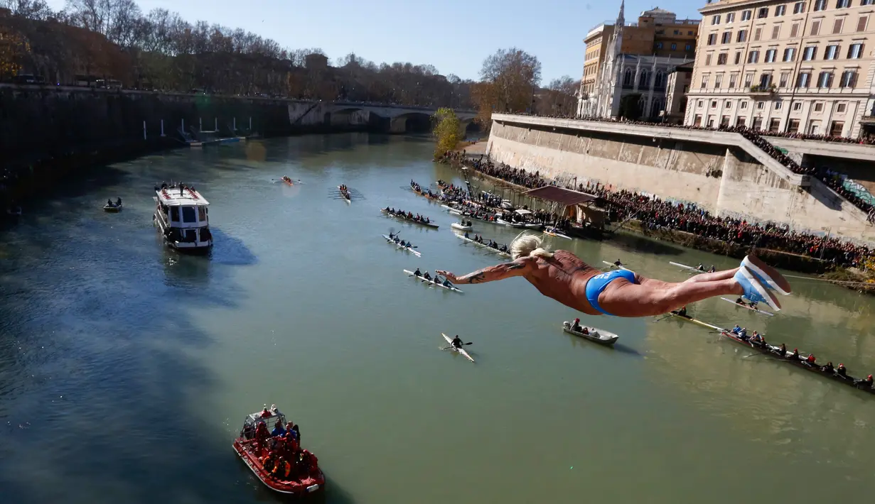 Maurizio Palmulli dari Italia melakukan terjun bebas ke sungai Tiber dari Jembatan Cavour di Roma, Selasa (1/1). Tradisi melompat dari jembatan setinggi 18 meter  dan menyelam ke sungai tersebut sebagai bentuk perayaan tahun baru. (AP/Riccardo De Luca)