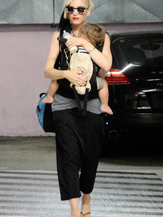 Sambil menggendong anak, Gwen Stefani menjadikan sandal jepit alas kaki yang nyaman untuk jalan-jalan. (BROADIMAGE/REX/Shutterstock/HollywoodLife)