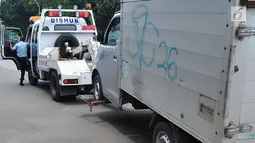 Mobil dari Dinas Perhubungan DKI Jakarta menderek mobil yang parkir di bahu jalan di kawasan Jatinegara, Jakarta, Senin (2/10). Razia ini juga bertujuan untuk memberi efek jera pengendara yang memarkir sembarangan. (Liputan6.com/Helmi Afandi)