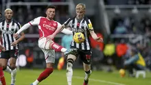 Penyerang Newcastle United Anthony Gordon berebut bola dengan bek Arsenal Ben White pada laga Premier League 2023/2024 pekan 11 yang digelar di St. James' Park, Minggu (5/11/2023) dini hari WIB. (Owen Humphreys/PA via AP)
