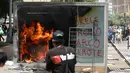 Mesin ATM bitcoin bernama Chivo terbakar selama protes terhadap kebijakan Presiden Nayib Bukele pada Hari Kemerdekaan di San Salvador, El Salvador, Rabu (15/9/2021). Ribuan warga juga memprotes Bukele yang dikhawatirkan kembali mengikuti pemilihan pada tahun 2024 mendatang. (MARVIN RECINOS/AFP)