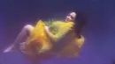 Dalam busana kuning, Nagita Slavina 'melayang' di bawah air. (via instagram/@raffinagita1717)