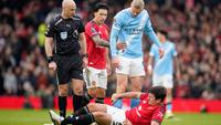 Harry Maguire dari Manchester United, di bagian bawah, tergeletak di lapangan kesakitan sementara wasit Anthony Taylor, Lisandro Martinez dari Manchester United, dan Erling Haaland dari Manchester City bereaksi selama pertandingan Liga Inggris antara Manchester United dan Manchester City di Manchester, Inggris, Sabtu, 17 Januari 2026. (AP Photo/Dave Thompson)