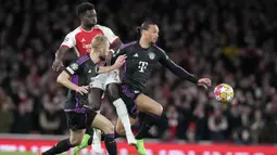 Gelandang Arsenal, Bukayo Saka (tengah) berebut bola dengan dua pemain Bayern Munchen, Konrad Laimer (kanan) dan Leroy Sane pada laga leg pertama babak perempatfinal Liga Champions 2023/2024 di Emirates Stadium, London, Selasa (9/4/2024) malam. (AP Photo/Frank Augstein)