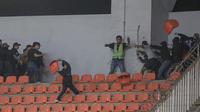 Sejumlah pendukung Persib Bandung (kiri) dan pendukung Persis Solo bersitengan saat pertandingan pekan ke-32 BRI Liga 1 2022/2023 antara Persib Bandung melawan Persis Solo yang berlangsung di Stadion Pakansari, Bogor, Selasa (04/04/2023). (Bola.com/Bagaskara Lazuardi)