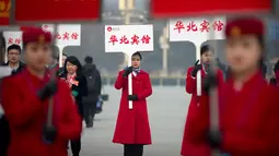 Sejumlah wanita memegang papan pengarahan saat menyambut peserta Kongres Rakyat Nasional di Beijing, China, Senin (4/3). Kongres ini dihadiri ribuan delegasi dari seluruh China. (AP Photo/Andy Wong)