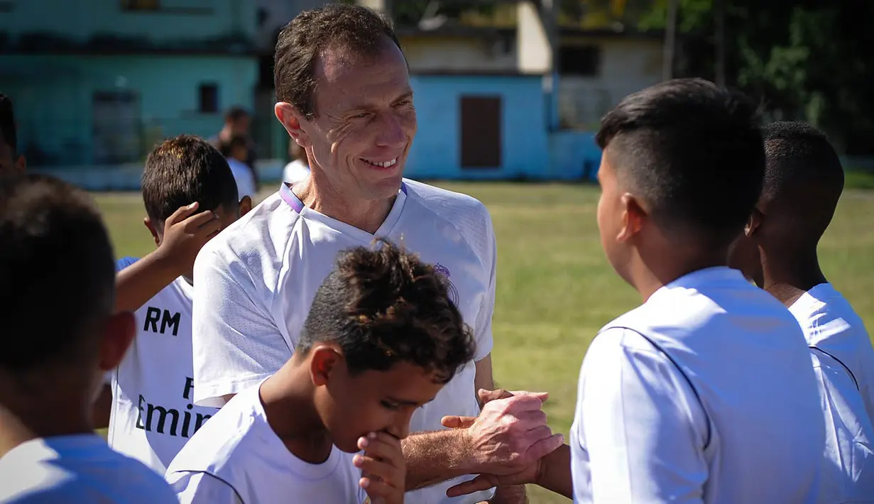 Emilio Butragueno menyalami anak-anak dari Real Madrid Foundation usai memberikan pelatihan sepak bola. (AFP/Yamil Lage)