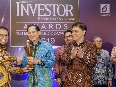 Presiden Direktur BCA Jahja Setiaatmadja (tengah) menerima penghargaan Emiten Terbaik 2019 untuk Top Performing Listed Companies 2019 oleh Deputi Komisioner Pengawas Pasar Modal 2A OJK Fakhri Hilmi (kiri) dalam Investor Awards 2019 di Jakarta, Kamis (16/5). (Liputan6.com/HO/Eko)