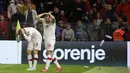 Penyerang Polandia Karol Swiderski (kiri) memegangi kepalanya saat suporter melemparkan botol tak lama setelah mencetak gol ke gawang Albania pada lanjutan Kualifikasi Piala Dunia 2022, di Air Albania Stadium, Rabu (13/10/2021) dini hari WIB. Polandia mengalahkan Albania 1-0. (AP Photo/Franc Zhurda)