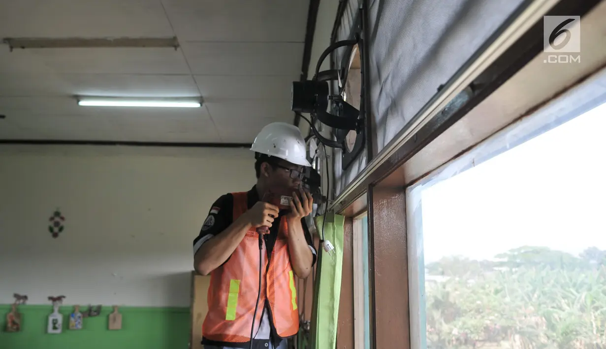Siswa SMK Negeri 4 Jakarta Utara memasang kipas angin dan penyaring udara di SD Negeri Cilincing 07 Pagi, Jakarta, Kamis (19/9/2019). Pemasangan tersebut menjadi bagian dari instalasi Sekolah Aman Asap. (merdeka.com/Iqbal Nugroho)