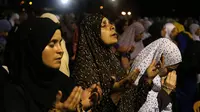 Umat muslim perempuan Palestina  tampak khusyuk memanjatkan doa di depan Kubah Batu, di kompleks Masjid Al Aqsa, Yerusalem, Senin (13/7/2015). Setiap malam Lailatul Qadar, kompleks Masjid Al Aqsa dipenuhi para umat muslim. (AFP PHOTO/Ahmad GHARABLI)